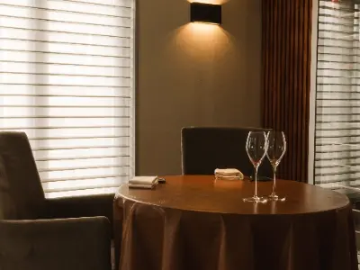 Afbeelding van tafel met wijnglazen en stoelen van restaurant De Burgemeester